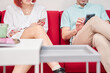 © Oscar - unrecognizable couple sitting on the sofa in a waiting room using their smartphones