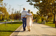 © Studio Romantic - Bonding, love and relationship. Happy romantic mature couple in love hugging together while walking on date in park. Rear view of mature husband and wife walking together on path in city park.