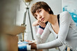 © LIGHTFIELD STUDIOS - A woman with hand on chin sits at a desk.
