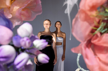 Wall Mural - women wearing tops while posing together on floral background