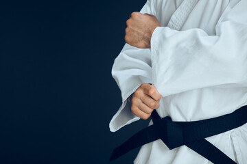 Canvas Print - Man, hands and ready for karate in studio, fighter and start for training or practice on dark background. Male person, athlete and warrior in dojo for martial arts, mockup space and sports technique