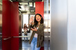 © Alba Vitta/Stocksy - Woman inside elevator using phone
