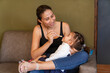 © Leonardo Borges Nuñez/Stocksy - Happy mother feeding disabled daughter on sofa