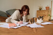 © Guille Faingold/Stocksy - Writing in her journal with cat t home