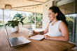 © Nicola Suttle/Stocksy - Smiling woman with cup of coffee during video chat