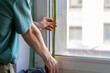 © Ivan Haidutski/Stocksy - man measuring the size of a window in a new home using measure tape
