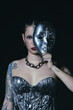 © Laura Herrera/Stocksy - Editorial fashion portrait of a woman with a silver mask and dress