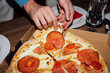 © Pixel Stories/Stocksy - Anonymous person holding slice of delicious pizza. Finger, fast food.