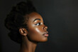 © AI_images - a close-up side view of a pretty young Black woman posing against a black background, capturing her elegant profile.