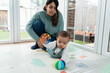 © nomad studio/Stocksy - Mother and baby playing on floor at home