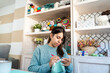 © nomad studio/Stocksy - Young woman focused on knitting in cozy craft room