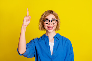 Poster - Photo of nice young girl point finger wear blue shirt isolated on yellow color background