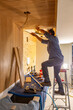 © Raymond Forbes LLC/Stocksy - Carpenter worker building Vertical wood paneling wall