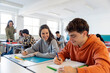 © Santi Nuñez/Stocksy - students smiling and studying in classroom