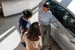 © Jovo Jovanovic/Stocksy - Couple learning about details of a car from a salesperson