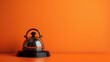 © Khalif - Beautiful hotel service bell on orange background with copy space, minimal concept. Photo taken