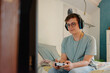 © Melissa Milis Photography/Stocksy - Young man playing video games at home