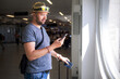 © Irina Efremova/Stocksy - Traveler with Smartphone and Passport at Airport