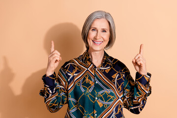 Wall Mural - Portrait of positive woman with bob hairdo dressed print shirt indicating at proposition empty space isolated on pastel color background