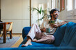© BONNINSTUDIO/Stocksy - Man with cup of coffee using smartphone at modern flat