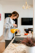 © DZ FILM/Stocksy - A woman pours juice in the kitchen