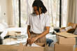 © Artem Podrez/Stocksy - Woman Unboxing New Purchase at cozy home