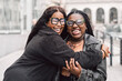 © Santi Nuñez/Stocksy - Two friendly women laughing together on the street