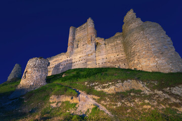 Wall Mural - Castle de Santiago or Torre de los Piquillos illuminated at night under a starry sky.