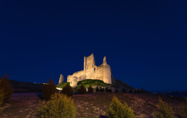 Wall Mural - Castle de Santiago or Torre de los Piquillos illuminated at night under a starry sky.