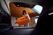 © Boris Jovanovic/Stocksy - Young woman puts a suitcase in the trunk