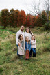 © Serena Burroughs/Stocksy - portrait of a young family outdoors in autumn
