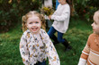 © Serena Burroughs/Stocksy - portrait of happy smiling girl with cousins outdoors in autumn