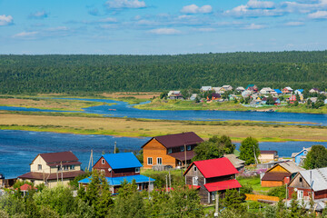 panoramic view of the river stretching into the distance among the hilly forest and the village on both sides of the river