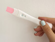 © Sonja Lekovic/Stocksy - Positive pregnancy test in hand closeup