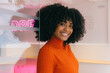 © VICTOR TORRES/Stocksy - Smiling woman in modern office with neon lighting