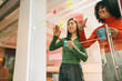 © VICTOR TORRES/Stocksy - Two women collaborating with sticky notes on glass