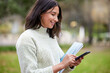 © peopleimages.com - Student, phone text and woman portrait in a park with learning, research and info on campus. Smile, mobile and university women with notes, social media and college test with a study break outdoor