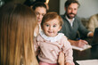 © VICTOR TORRES/Stocksy - Family moment with a happy baby in business meeting