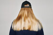 © Irina Bo/Stocksy - Woman with long blond hair wearing a cap