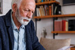 © Jovo Jovanovic/Stocksy - Depressed senior man sitting at home
