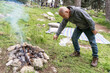 © Inna Reznik/Stocksy - Senior Man Making Campfire in Forest.