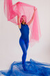 © Tania Cervian/Stocksy - Slim lady in bodysuit covering face with pink material
