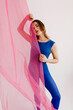 © Tania Cervian/Stocksy - Dreamy gymnast covering half body with transparent pink fabric