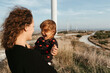 © Irina Polonina/Stocksy - Joyful Mother and Child Near Windmills at Sunset