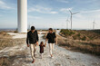 © Irina Polonina/Stocksy - Family Walk by Wind Turbines at Dusk