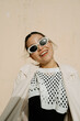 © Azamat Mukanov/Stocksy - selfies Smiling woman in sunglasses against a beige wall