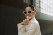 © Azamat Mukanov/Stocksy - Smiling Asian Woman in Sunglasses