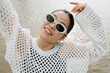 © Azamat Mukanov/Stocksy - Asian woman in sunglasses by the boardwalk.