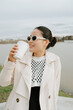 © Azamat Mukanov/Stocksy - Asian woman in sunglasses with coffee