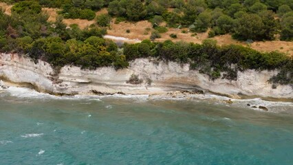 Wall Mural - Aerial 4k video of waves hitting the rocks on the beach